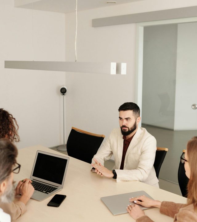 Man in White Suit Jacket Sitting Having an Interview